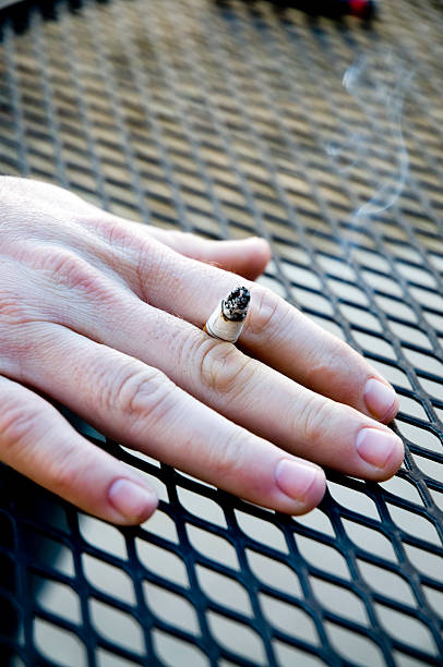 Smoking Hand holding burning cigarette theishkid stock pictures, royalty-free photos & images