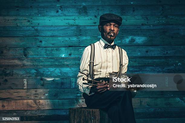 Smoking vintage african american senior jazz musician with trumpet.