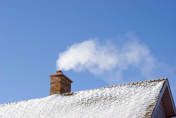 Smoking Winter Chimney White smoke comes out of a house's chimney on a winter day. chimney stock pictures, royalty-free photos & images