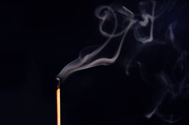 Smoldering Matchstick A matchstick smolders slowly. wispy stock pictures, royalty-free photos & images