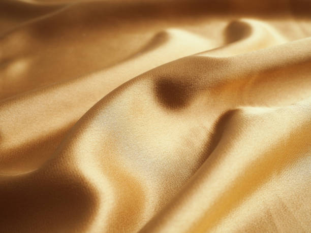 Smooth elegant golden silk can use as wedding background. In Sepia toned. Retro style. silk fabric artistic layout. Texture, background. template. stock photo
