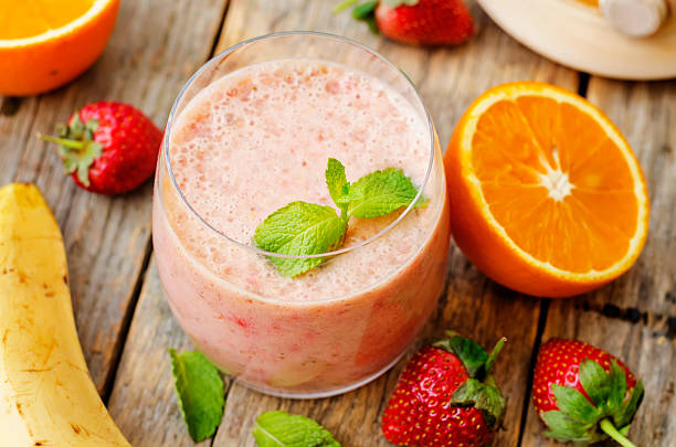 smoothie with strawberries, banana and orange smoothie with strawberries, banana and orange. the toning. selective focus orange smoothie stock pictures, royalty-free photos & images