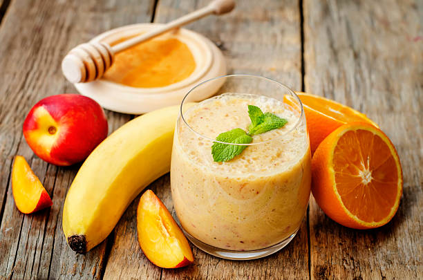 smoothies with peaches, banana and orange smoothies with peaches, banana and orange. the toning. selective focus peach smoothie stock pictures, royalty-free photos & images