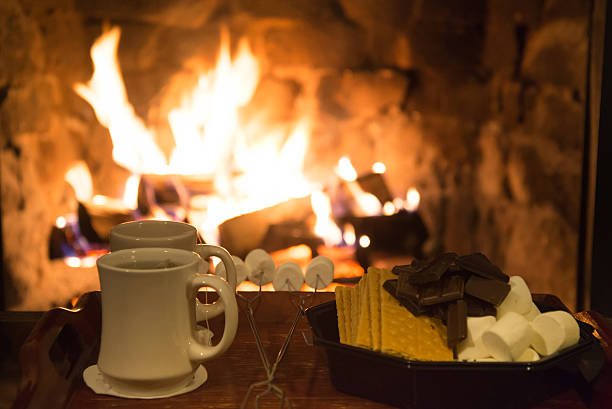 Smores treats and hot tea in front of a fireplace stock photo