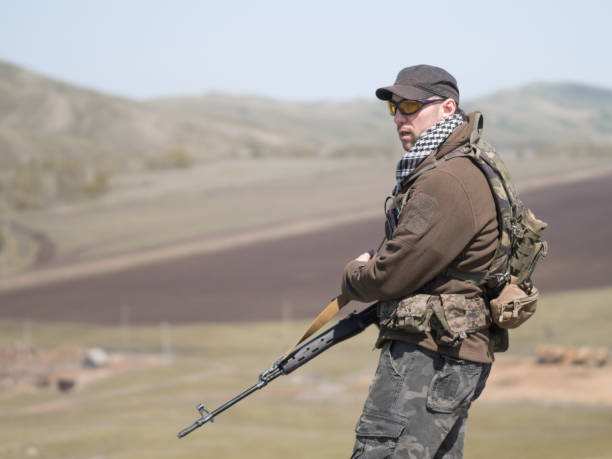 sniper standing with arms and looking to the side. sniper standing with arms and looking to the side. Armed conflict. Terrorist militia stock pictures, royalty-free photos & images