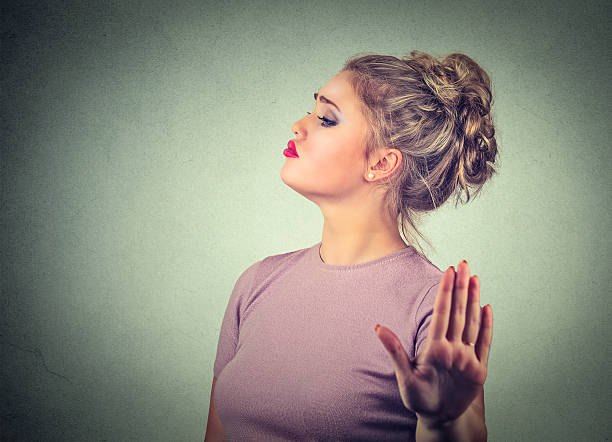 Snobby annoyed woman giving talk to hand gesture Snobby young annoyed angry woman with bad attitude giving talk to hand gesture with palm outward isolated grey wall background. Negative human emotion face expression feeling body language snob stock pictures, royalty-free photos & images