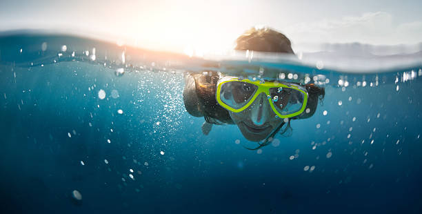 Snorkeling in the sea Close up split shot of the young lady snorkeling in the clear tropical sea woman snorkeling stock pictures, royalty-free photos & images