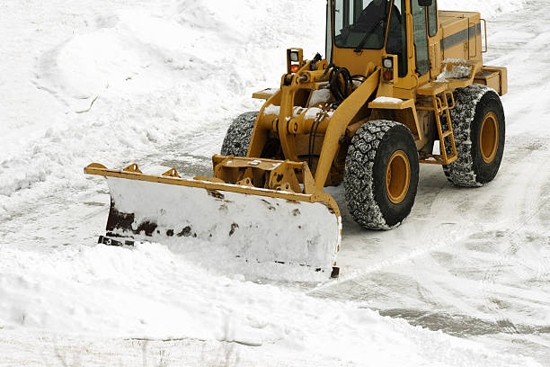 Snow Be Gone! huge plow clearing parking lot after storm stock photo