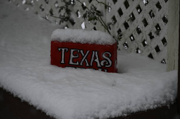 Snow in texas Red brick with Texas sign sitting in snow drift on bench on patio deck with lattice background snow in texas stock pictures, royalty-free photos & images