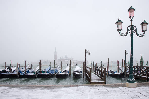 Snow on Venetian gondolas, St. Mark square, Venice, Italy stock photo