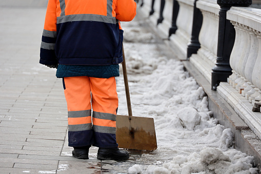 Worker in uniform with shovel, street cleaning