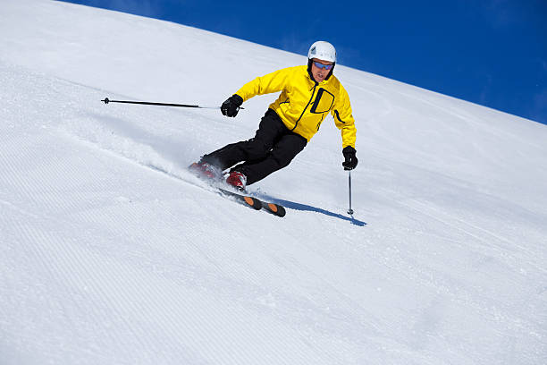 Snow skier, skiing carving at high speed, mountain ski resort in the...