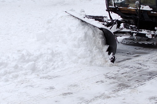 snowblower removes snow from the footpath in the city