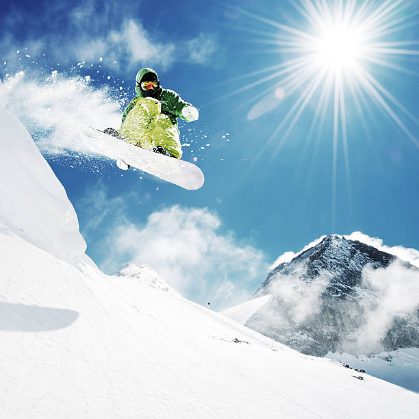Snowboarder at jump in high mountains stock photo
