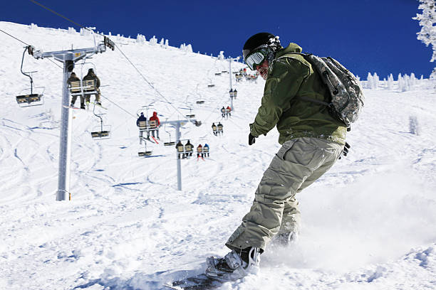 Snowboarder in Action and Chairlift Snowboarder in action, Snowbird, Utah, USA powder mountain stock pictures, royalty-free photos & images