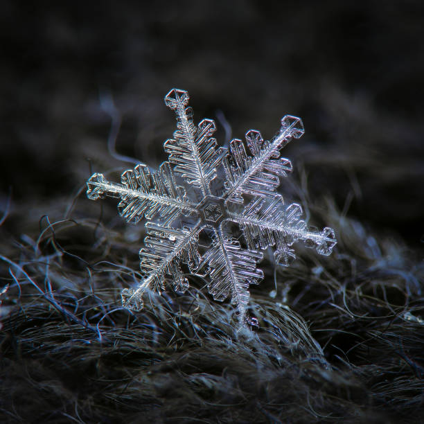 Snowflake glowing on dark textured background stock photo