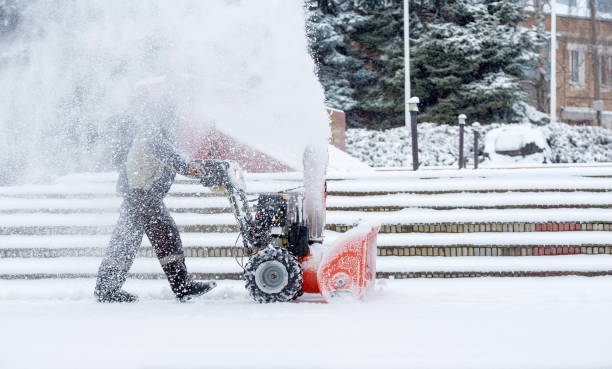 Snow-removal work with a snow blower. Man Removing Snow. heavy precipitation and snow pile stock photo