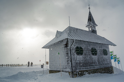 Snowy and cloudy view of chapel at mountains near Zell am See, Austria.