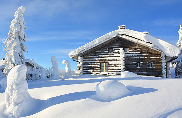 Snowy cottage on mountain Cottage on snowy mountain on a sunny cold winter day on tourist resort in Lapland Finland. Cottages and spruce trees are covered by heavy snow.  finnish lapland stock pictures, royalty-free photos & images