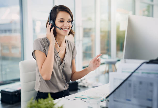 So the first step is... Cropped shot of an attractive young woman using a headset while sitting at her desk in the office headset woman customer service stock pictures, royalty-free photos & images