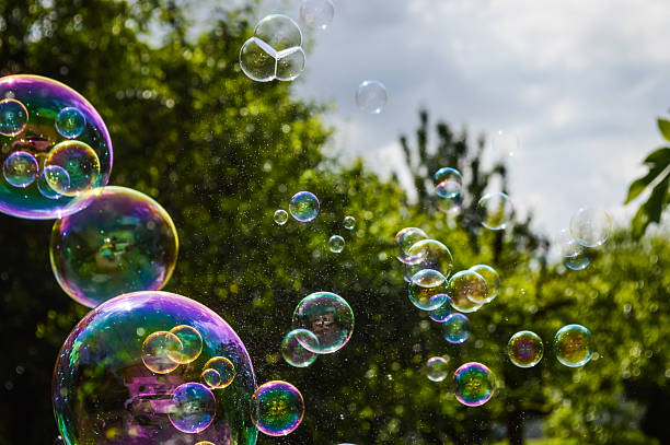 soap bubbles floating on green garden background soap bubbles floating on green garden background. bubble wand stock pictures, royalty-free photos & images