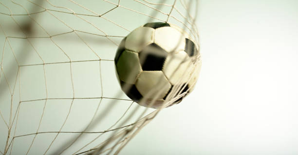 Soccer ball in the net Scoring goal, Soccer ball in the net against gray background. goal sports equipment stock pictures, royalty-free photos & images