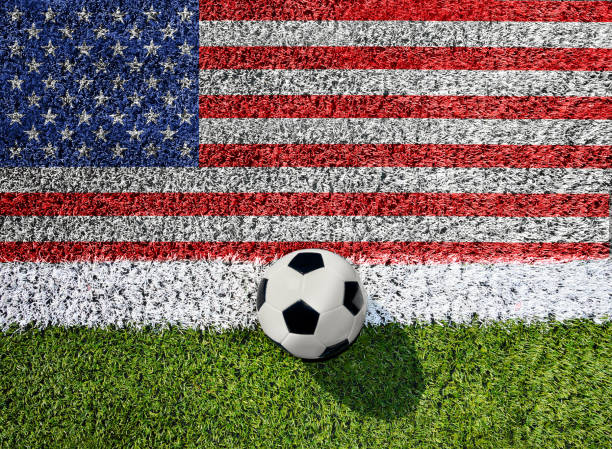 pelota de fútbol sobre hierba verde con bandera americana - american football fotografías e imágenes de stock