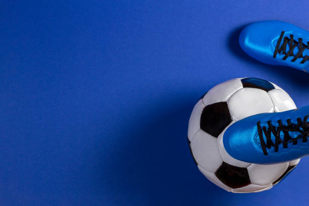 soccer ball under soccer players feet on blue background - futsal imagens e fotografias de stock