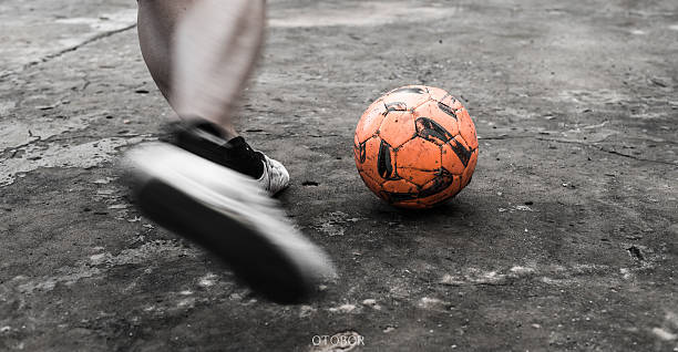 soccer ball with his feet on the football field - boys football boots 個照片及圖片檔
