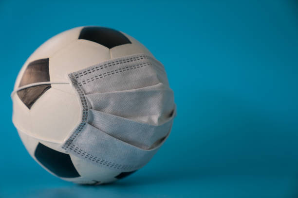Soccer ball with protective mask - Virus stock photo
