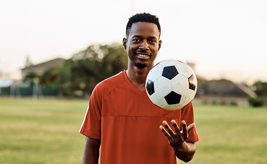 Shot of a soccer player holding a ball while out on the field