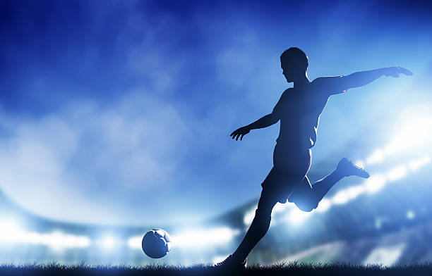 jogador de futebol chuta a bola se prepara para dentro da baliza - soccer night imagens e fotografias de stock