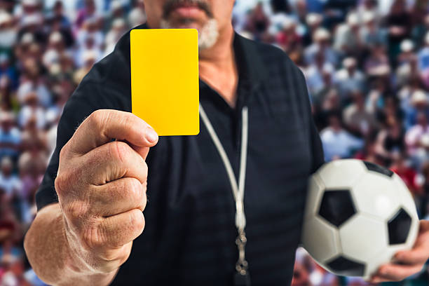 soccer referee holding a yellow card at camera - gele kaart stockfoto's en -beelden