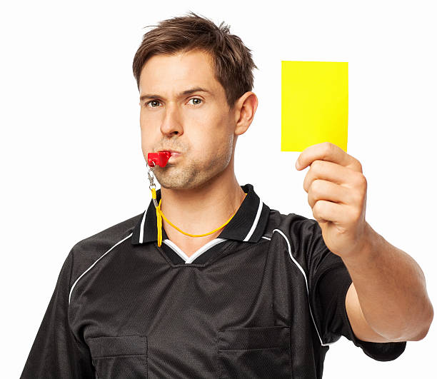 soccer referee whistling while showing yellow card - gele kaart stockfoto's en -beelden