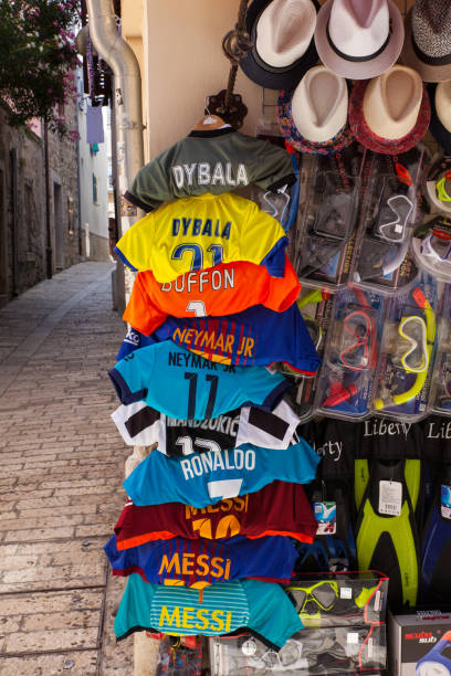 Soccer shirts hang outside a shop Porec, Croatia - July, 14: Soccer shirts hang outside a shop on July 14, 2017 messi stock pictures, royalty-free photos & images