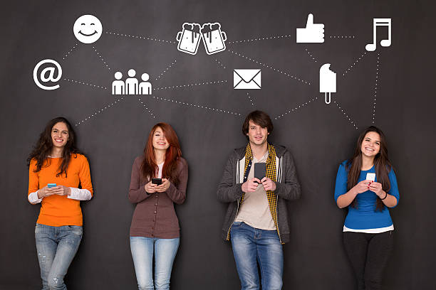 Social media concept Four people texting in front of a blackboard in social media concept. big smile emoji stock pictures, royalty-free photos & images