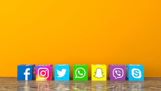 Social media services icons with on wooden desk with an orange color wall Istanbul, Turkey - February 28, 2019: Cube shape of popular social media services icons, including Facebook, Instagram, Twitter, Whatsapp, Snapchat, Viber, Skype on wooden desk with an orange color wall brand name stock pictures, royalty-free photos & images