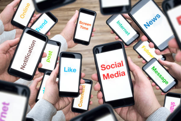 Social media terms on many smartphone screens A lot of smartphones held in hand with social media terms on the screens. excess stock pictures, royalty-free photos & images