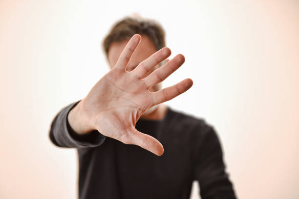 Social victim man with problems hiding face with hand stock photo