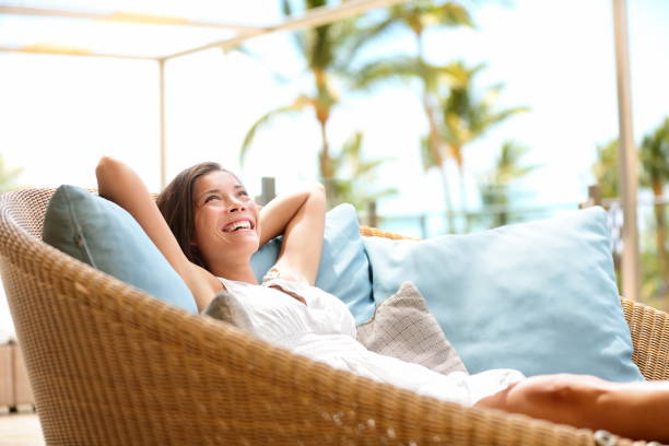 Sofa Woman relaxing enjoying luxury lifestyle Sofa Woman relaxing enjoying luxury lifestyle outdoor day dreaming and thinking looking happy up smiling cheerful. Beautiful young multicultural Asian Caucasian female model in her 20s. affluent lifestyles stock pictures, royalty-free photos & images
