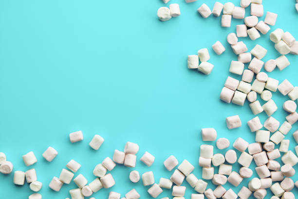 Soft pink and white marshmallows on light blue background. stock photo