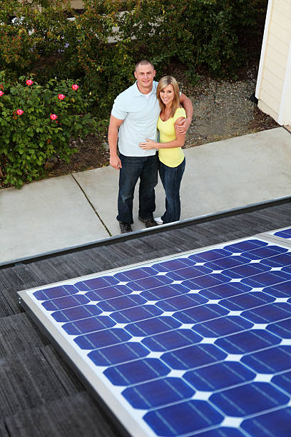 Solar Family Homeowners admiring their new solar electric panels on their house. gchutka stock pictures, royalty-free photos & images
