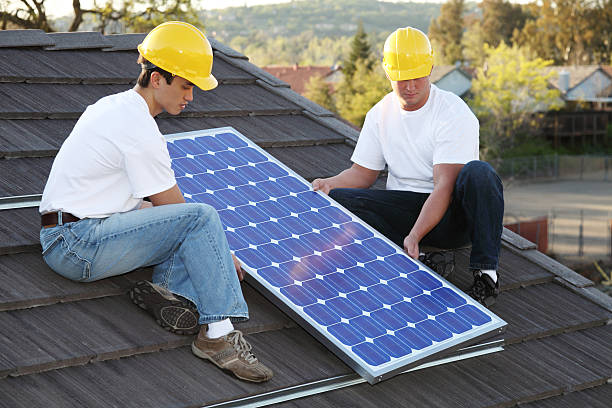 Solar Installers On Roof  gchutka stock pictures, royalty-free photos & images