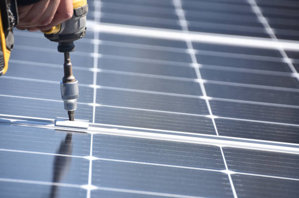 Solar panel installer with drill stock photo