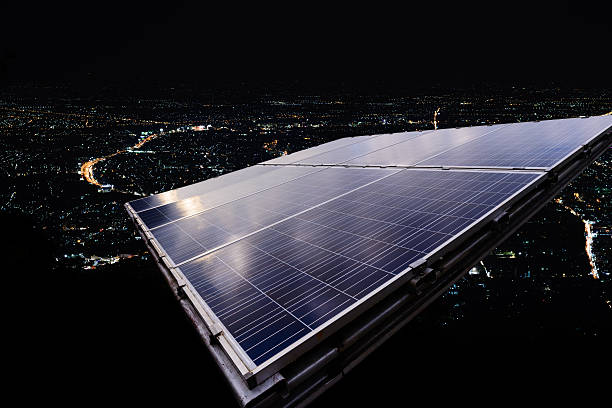 Solar panel with city night light. stock photo