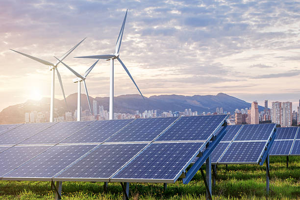 Solar panels and wind turbines with city stock photo