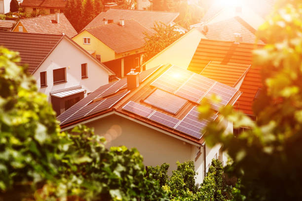 太陽の下で建物のタイル張りの屋根の上にソーラーパネル。ブドウの葉を通してトップビュー。エネルギー、自立、自律性、セキュリティに関するイラストレーションの画像。 - 太陽光パネル ストックフォトと画像