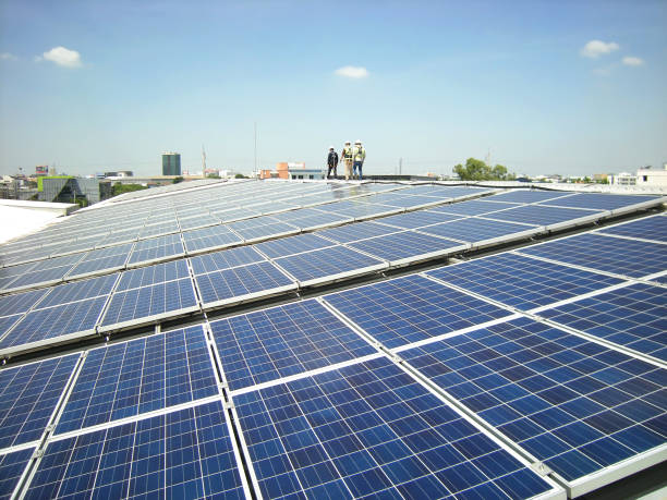 zonne-pv op het dak met werknemers lopen - zonnepanelen warehouse stockfoto's en -beelden