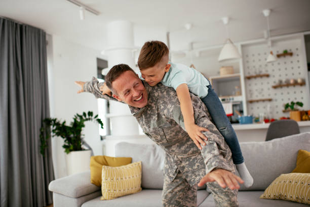 Soldier enjoying at home with children. stock photo