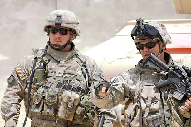 A soldier in a war zone giving orders A U.S. Army Staff Sergeant (SSG) directs soldiers.  us military stock pictures, royalty-free photos & images